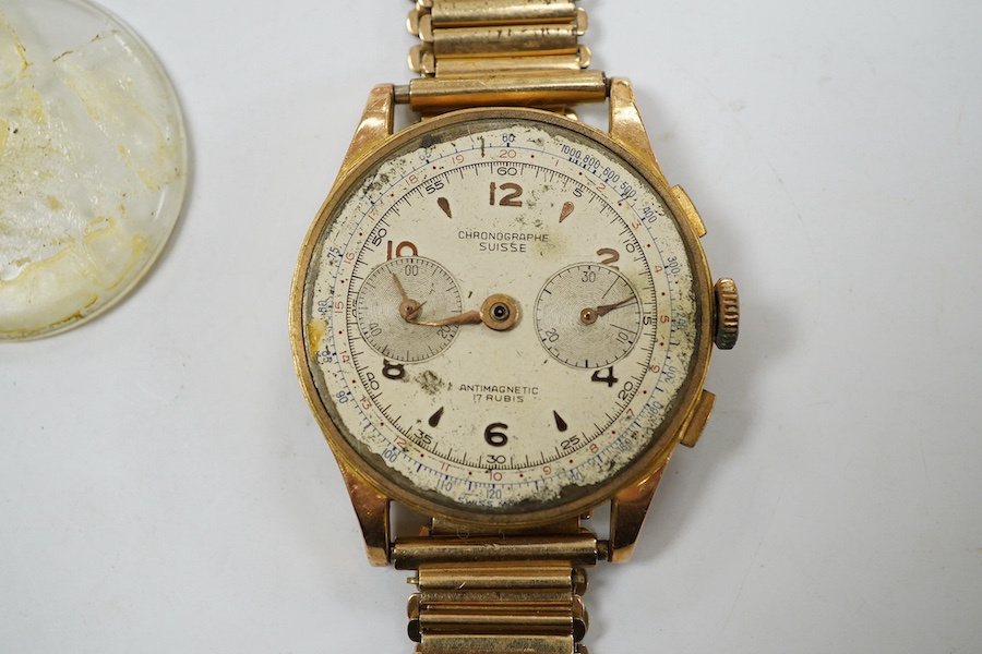 A gentleman's yellow metal Swiss chronograph manual wind wrist watch (lacking back cover), on a gold plated strap. Condition - poor.